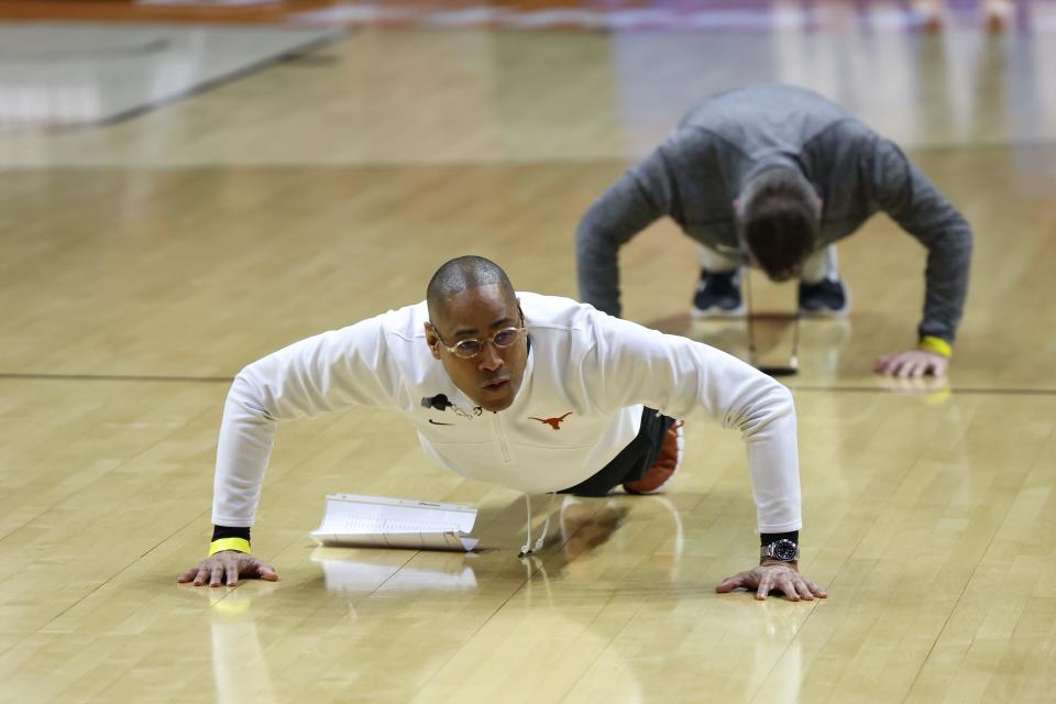 Texas interim head coach Rodney Terry does push-ups along with his players during the Longhorns' practice session Wednesday at Wells Fargo Arena in Des Moine, Iowa, where they will open their NCAA Tournament on Thursday evening against Colgate.