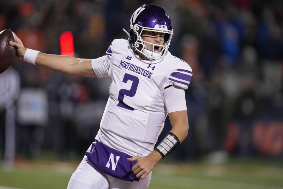 Northwestern quarterback Ben Bryant holds the ball as he runs in an 8-yard touchdown during the second half of an NCAA college football game against Illinois, Saturday, Nov. 25, 2023, in Champaign, Ill. (AP Photo/Erin Hooley)