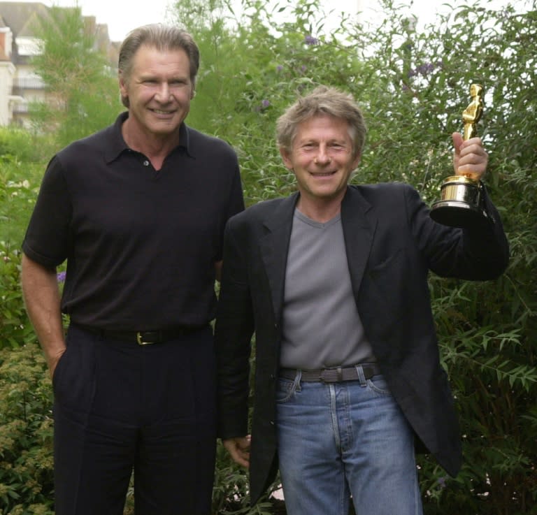 Film director Roman Polanski (R) shows his Oscar statuette, awarded for his movie 'The Pianist', after actor Harrison Ford brought it from Hollywood, in Deauville, in 2003