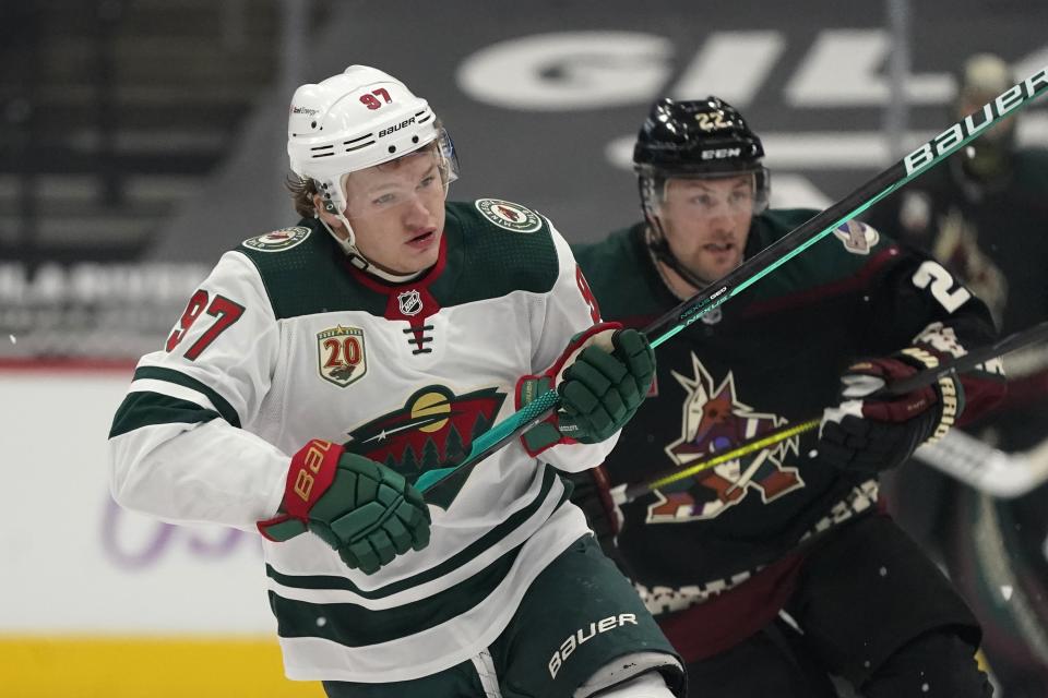 FILE - In this Monday, April 19, 2021 file photo, Minnesota Wild left wing Kirill Kaprizov (97) and Arizona Coyotes left wing Johan Larsson (22) skate down ice during the first period of an NHL hockey game in Glendale, Ariz. Kirill Kaprizov not only is the top scoring rookie in the NHL, he’s also Minnesota’s hottest player as the Wild look to win their first playoff series since 2015. (AP Photo/Ross D. Franklin, File)