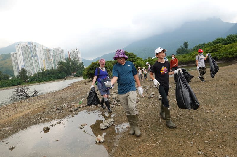 Climate activists Rose Netherton, 36, Lance Lau, 11, and Elise Hon, 11, take part in a climate strike and a beach clean-up with other participants at San Tau Beach on Lantau island in Hong Kong