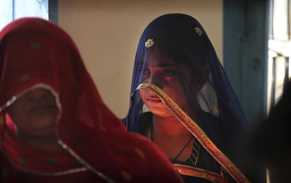 FILE - In this May 6, 2019, file photo, Indian women stand in a queue to cast their votes at a polling station at a village in Neemrana, in the Indian state of Rajasthan. The final phase of India’s marathon general election will be held on Sunday, May 19. The first of the election’s seven staggered phases was held on April 11. Vote counting is scheduled to start on May 23. India has 900 million eligible voters. (AP Photo/Manish Swarup, File)