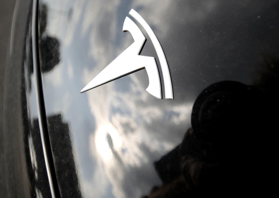 FILE - Clouds are reflected above the company logo on the hood of a Tesla vehicle outside a showroom in Littleton, Colo. A criminal prosecution against a Tesla driver in Los Angeles County will end on Tuesday, Aug. 15, 2023, the final step of a case believed to be the first time in the U.S. that prosecutors brought felony charges against a motorist who was using a partially automated driving system. (AP Photo/David Zalubowski, File)