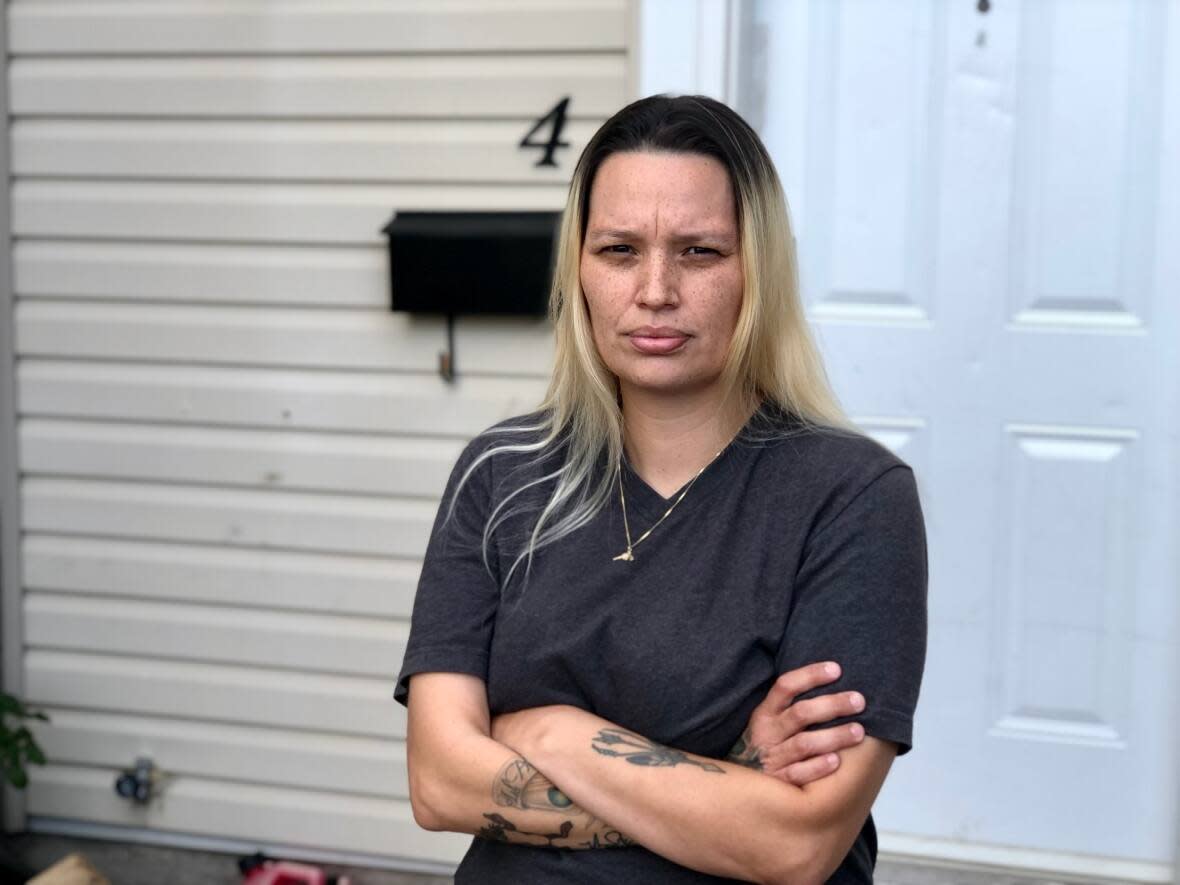 Kayla Fraser Jacobs stands in front of her London Housing townhouse on Shelborne Street in southwestern Ontario, but she's been living in a hotel since July with her five children because of the condition of the unit. (Rebecca Zandbergen/CBC News - image credit)