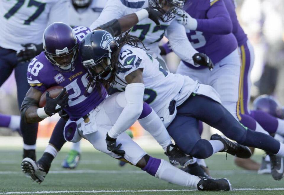 Minnesota Vikings running back Adrian Peterson (28) is tacked by Seattle Seahawks cornerback Richard Sherman (25) during the first half of an NFL wild-card football game, Sunday, Jan. 10, 2016, in Minneapolis. (AP Photo/Kiichiro Sato)