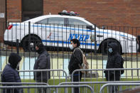 Patients wearing personal protective equipment stand on line while maintaining social distancing before entering a COVID-19 testing site at Elmhurst Hospital Center, Wednesday, March 25, 2020, in New York. Gov. Police have stepped up efforts to pressure New Yorkers to practice social distancing at the epicenter of the crisis. It's part of a global challenge that law enforcement and health officials say is critical to containing the coronavirus. (AP Photo/John Minchillo)