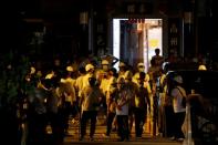 Men in white T-shirts and carrying poles are seen in Yuen Long after attacking anti-extradition bill demonstrators at a train station in Hong Kong