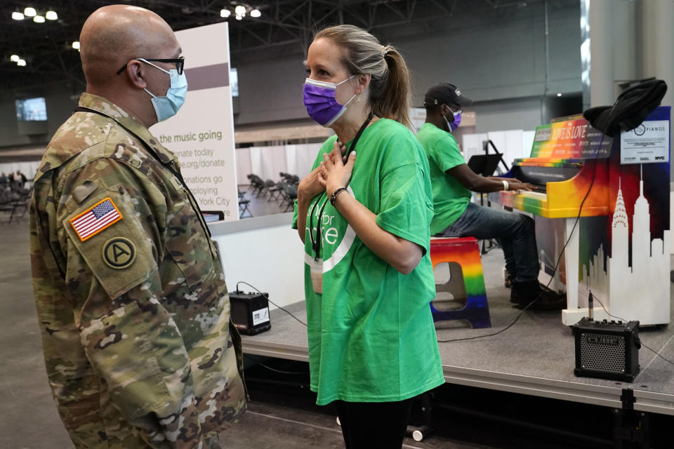 FILE - Violinist Victoria Paterson reacts as as a New York National Guard member speaks to her about the music she and fellow musicians like composer Harold O'Neal, behind them, right, play during daily lunchtime concerts at the Jacob K. Javits Convention Center, March 23, 2021, in New York.Up to 40,000 Army National Guard soldiers across the country - or about 13% of the force — have not yet gotten the mandated COVID-19 vaccine, and as the deadline for shots looms, at least 14,000 of them have flatly refused and could be forced out of the service. (AP Photo/Kathy Willens, File)