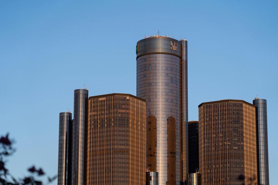 A sign at the top of the General Motors Renaissance Center in downtown Detroit is being worked on as the sun sets on the building on Monday, November 13, 2023.