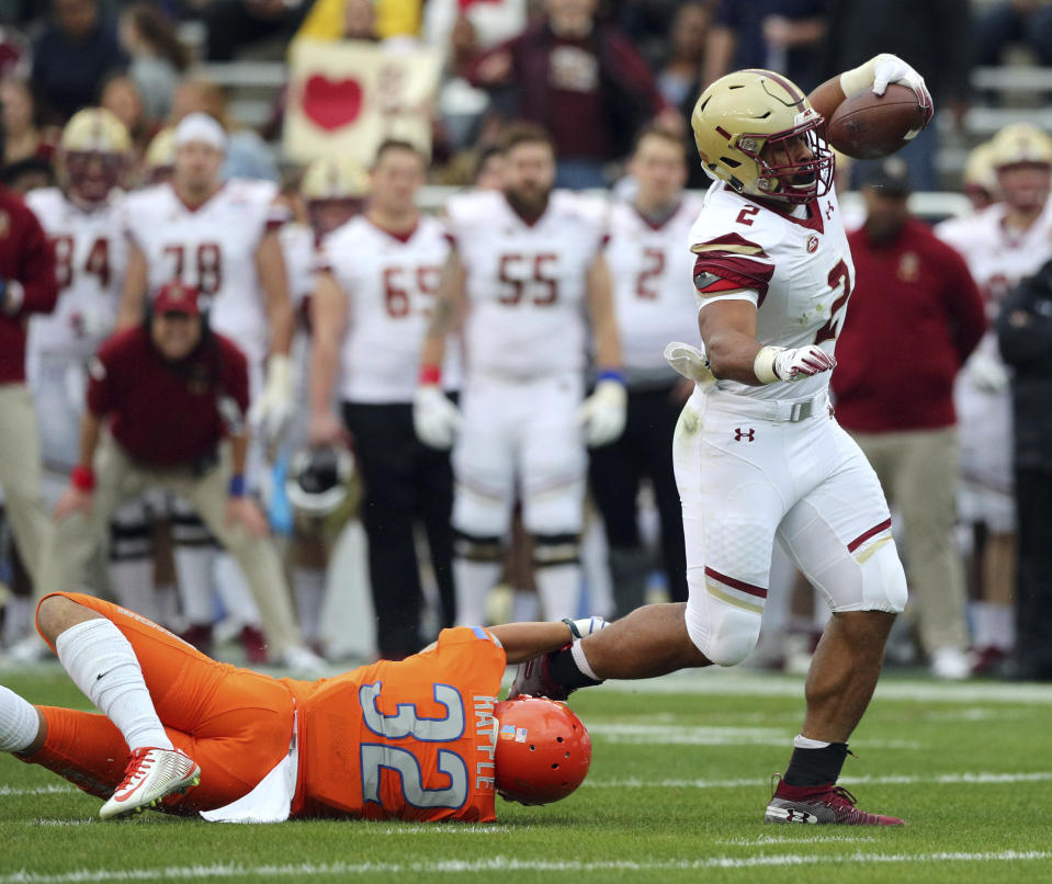 Boston College running back AJ Dillon (2) breaks a tackle by Boise State safety Jordan Happle (32) on a touchdown run during the first half of the First Responder Bowl NCAA football game Wednesday, Dec. 26, 2018, in Dallas. (AP Photo/Richard W. Rodriguez)