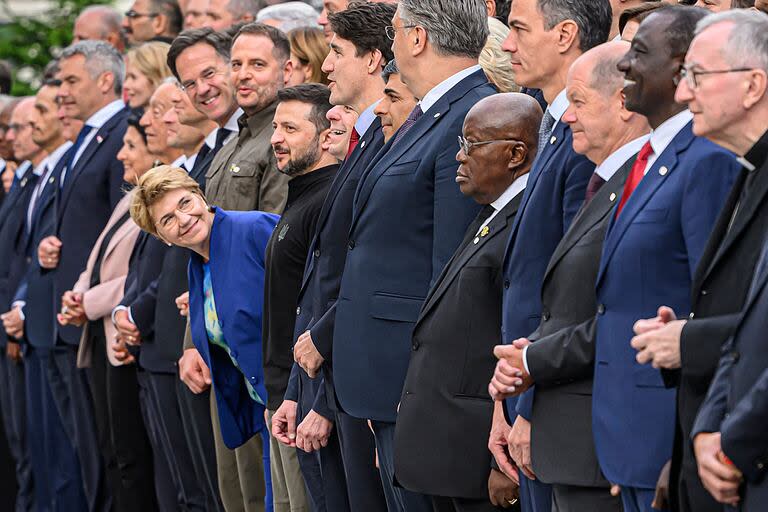 La presidenta suiza, Viola Amherd, mira a Zelensky mientras se sacan la foto de familia