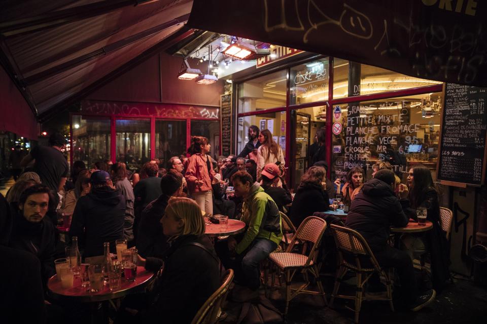 People enjoy a drink on a bar terrace in Paris, Monday, Oct. 5, 2020. 