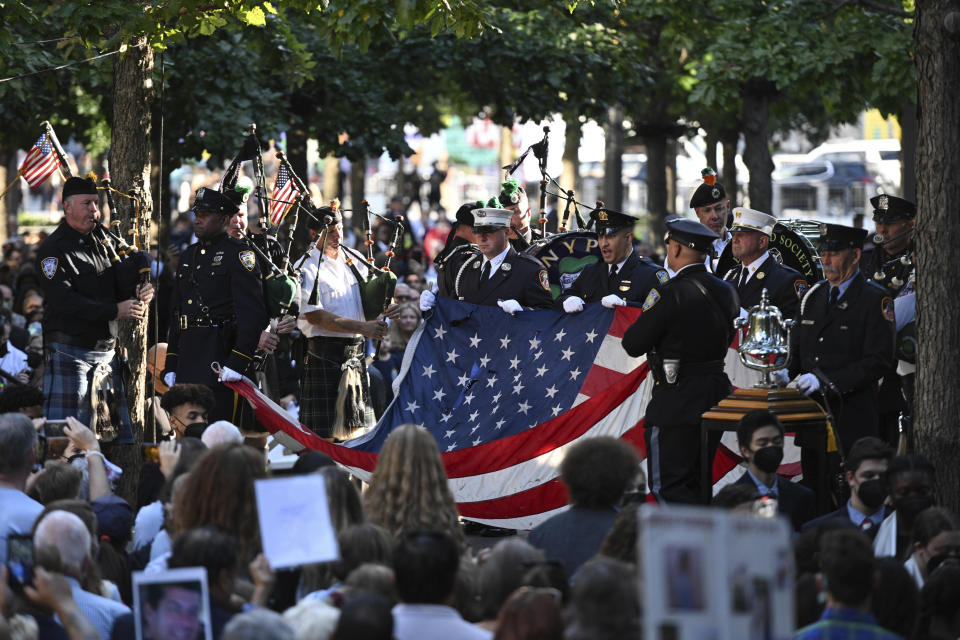 Photo by: NDZ/STAR MAX/IPx 2021 9/11/21 Members of the Fire Department of New York and New York City Police Department carry a damaged American flag near the memorial pools at the National September 11 Memorial & Museum during a commemoration ceremony for the 20th anniversary of the 9/11 attacks on September 11, 2021 in New York.