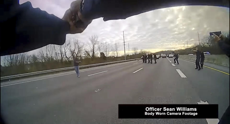 This still image from police body cam released by Metropolitan Nashville Police Department shows officers pleading with a man to surrender before shooting him on Jan. 28, 2022 in Nashville, Tenn. Tennessee police officers repeatedly pleaded with a man who stopped traffic along Interstate 65 to drop a box cutter and surrender, saying no one wanted to hurt him. Instead, he abruptly pulled another shiny object from his pocket and pointed it at police as if ready to shoot, prompting nine of the officers who surrounded him at gunpoint to open fire, killing him on the highway, according to officials and body camera video. (Metropolitan Nashville Police Department via AP)