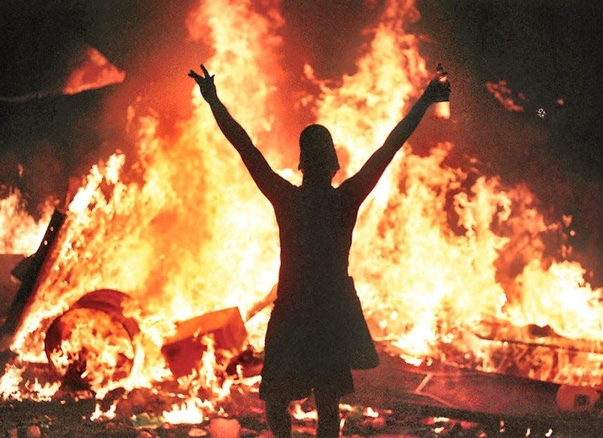This iconic image taken by former Observer-Dispatch photographer Michael P. Doherty of flames and chaos at Woodstock '99 summed up the three-day festival for those attending or those watching from afar.