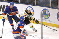 Boston Bruins' Brad Marchand (63) goes for the puck ahead of New York Islanders' Nick Leddy (2) and Anthony Beauvillier (18) during the second period of an NHL hockey game Monday, Jan. 18, 2021, in Uniondale, N.Y. (AP Photo/Jason DeCrow)