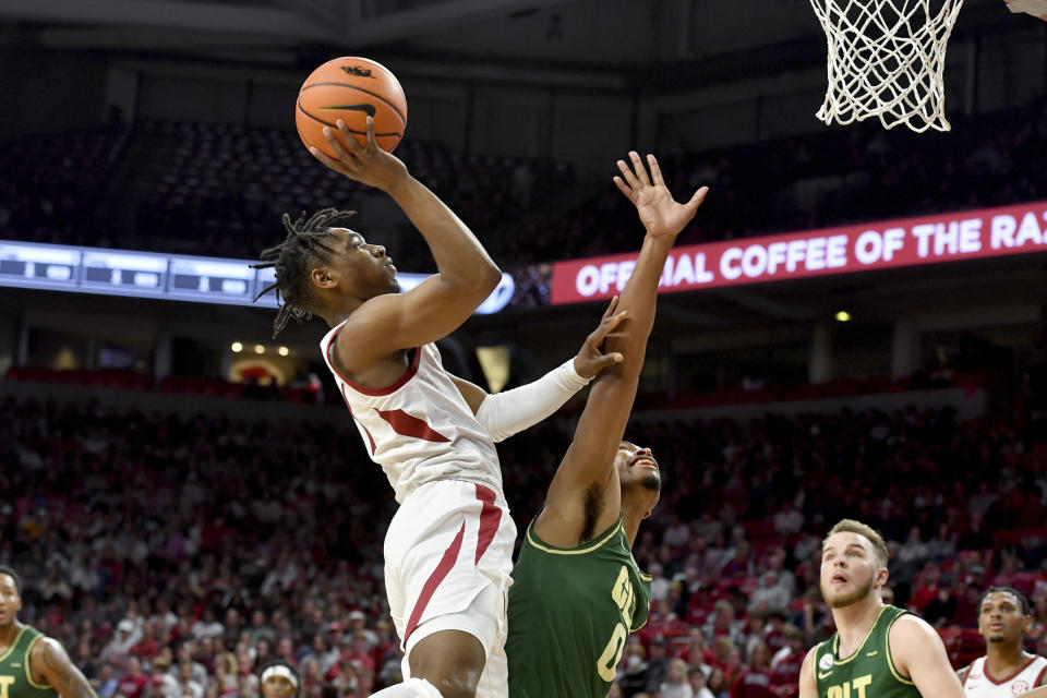 Arkansas guard JD Notae (1) shoots over Charlotte guard Clyde Trapp (0) during the first half of an NCAA college basketball game Tuesday, Dec. 7, 2021, in Fayetteville, Ark. (AP Photo/Michael Woods)