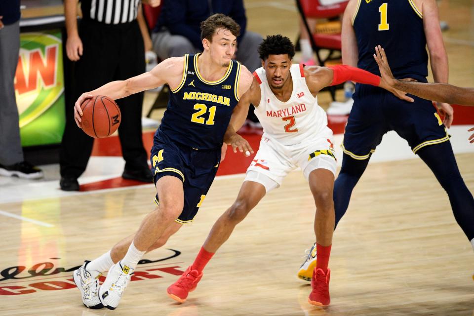 Michigan guard Franz Wagner (21) dribbles the ball next to Maryland guard Aaron Wiggins (2) during the second half of an NCAA college basketball game, Thursday, Dec. 31, 2020, in College Park, Md. Michigan won 84-73.