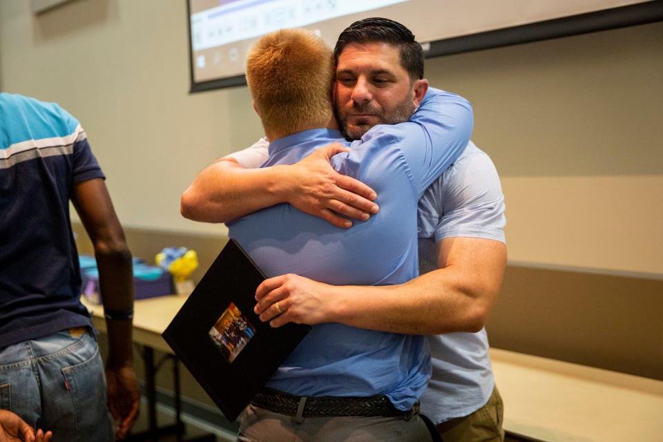 Steven Newell hugs program director Mike Wexler after giving him a thank you gift during the banquet for the Naples High School Career Transition and Experience program at Naples Botanical Garden on Wednesday, May 29, 2019.