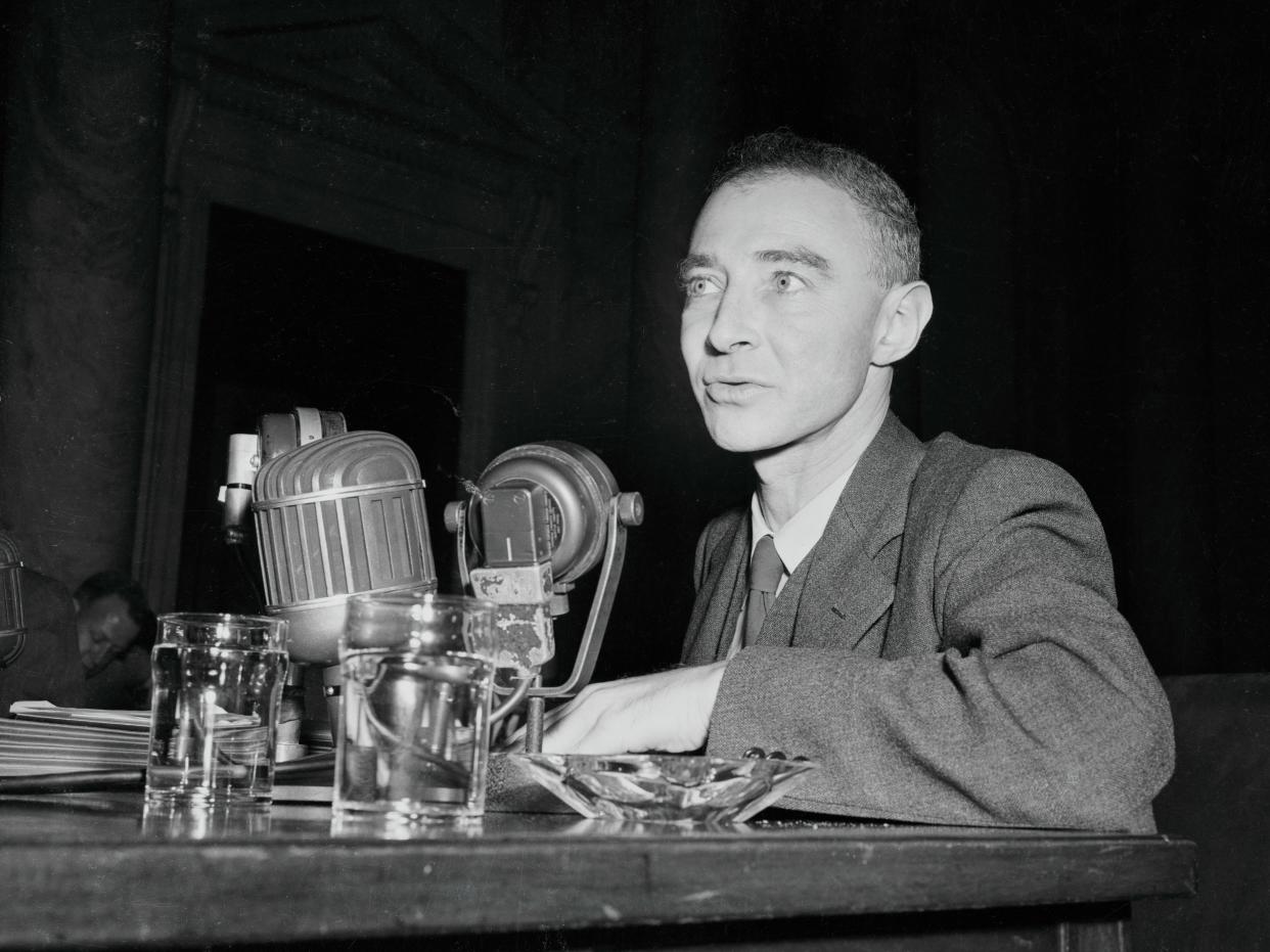 J. Robert Oppenheimer sitting in front of microphones during a hearing.