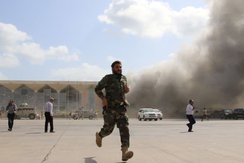 FILE PHOTO: Security personnel and people react during an attack on Aden airport moments after a plane landed carrying a newly formed cabinet for government-held parts of Yemen, in Aden