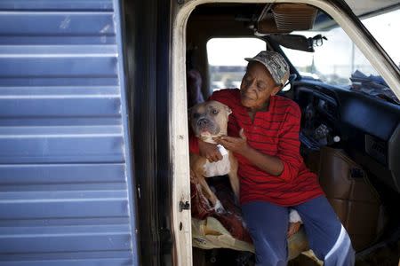 Pamela Polk, 56, hugs her dog inside a recreational vehicle (RV) in which she lives on the streets of Los Angeles, California, United States, November 12, 2015. REUTERS/Lucy Nicholson