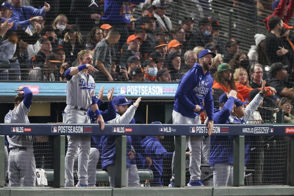 The Los Angeles Dodgers dugout cheers after an RBI double by Corey Seager