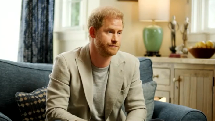 Prince Harry seated on blue chair for interview