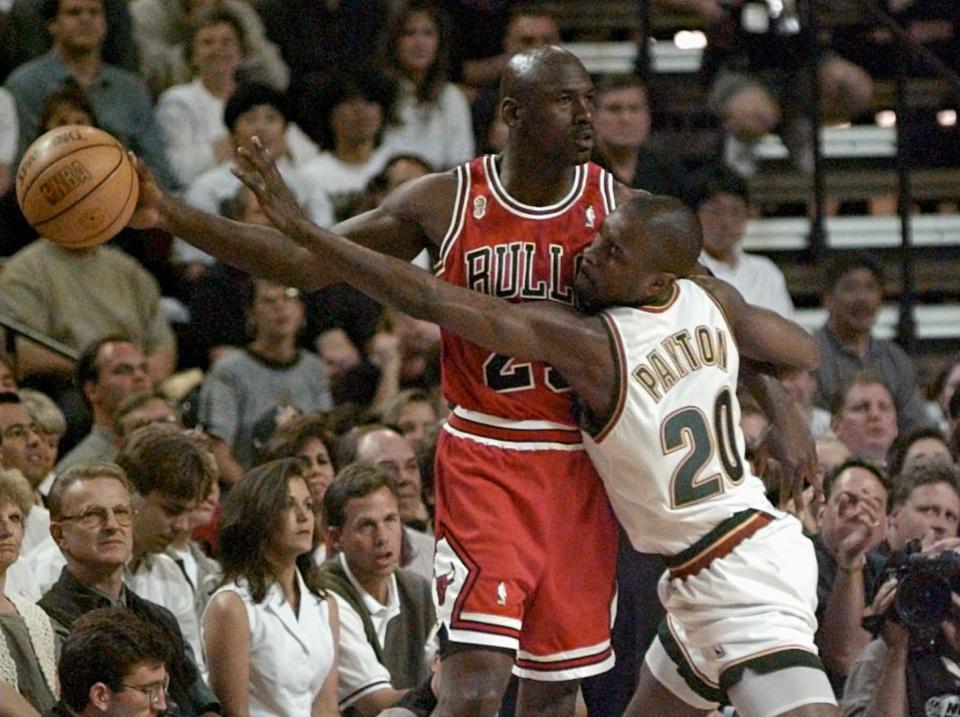 Chicago Bulls guard Michael Jordan holds the ball away from  the Seattle SuperSonics' Gary Payton (20) during the first quarter of Game 4 in the NBA Finals Wednesday, June 12, 1996, in Seattle.  (AP Photo/Elaine Thompson)