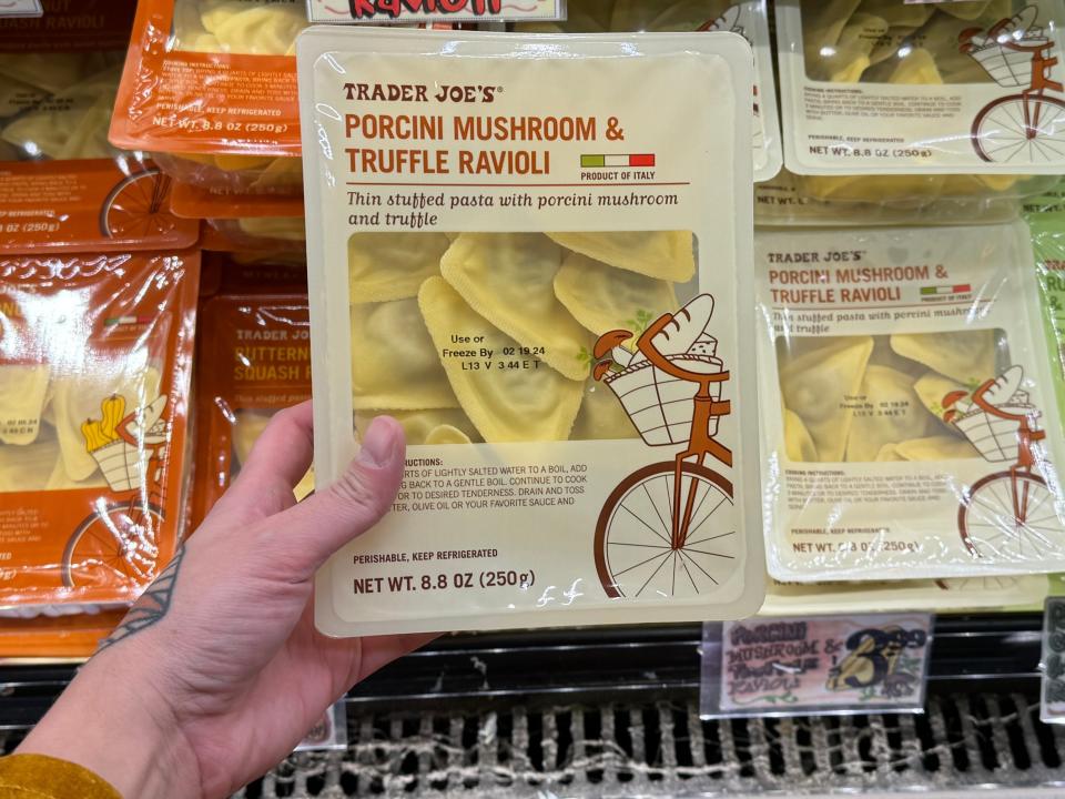 hand holding up a package of premade mushroom ravioli at trader joes