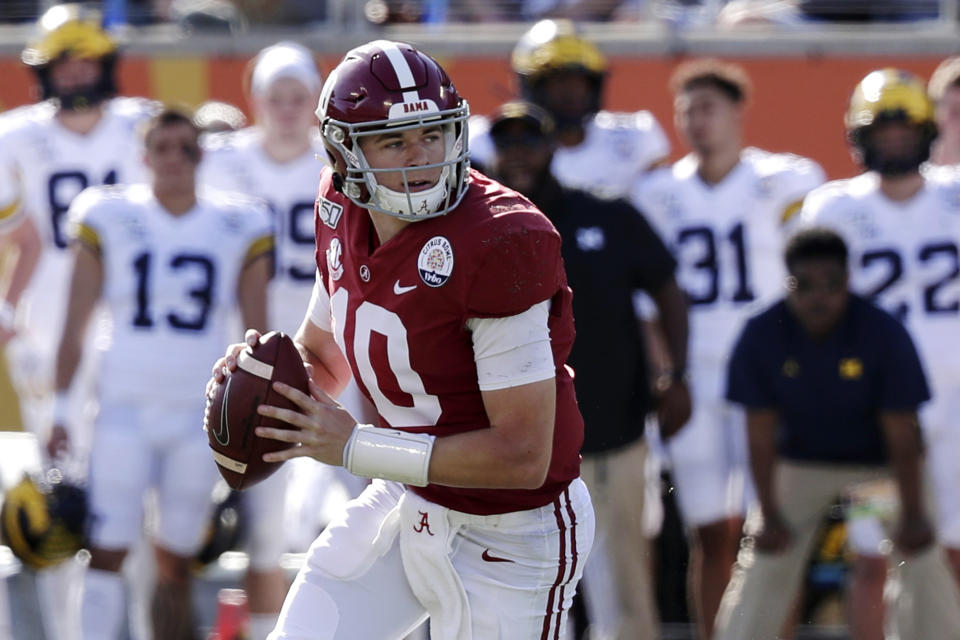 FILE - In this Jan. 1, 2020, file photo, Alabama quarterback Mac Jones (10) rolls ut as he looks for a receiver during the first half of the Citrus Bowl NCAA college football game against Michigan in Orlando, Fla. No. 2 Alabama doesn’t look like a team that lost quarterback Tua Tagovailoa and two first-round receivers. Mac Jones still has a selection of some of the SEC’s best playmakers, including Jaylen Waddle. (AP Photo/John Raoux, File)