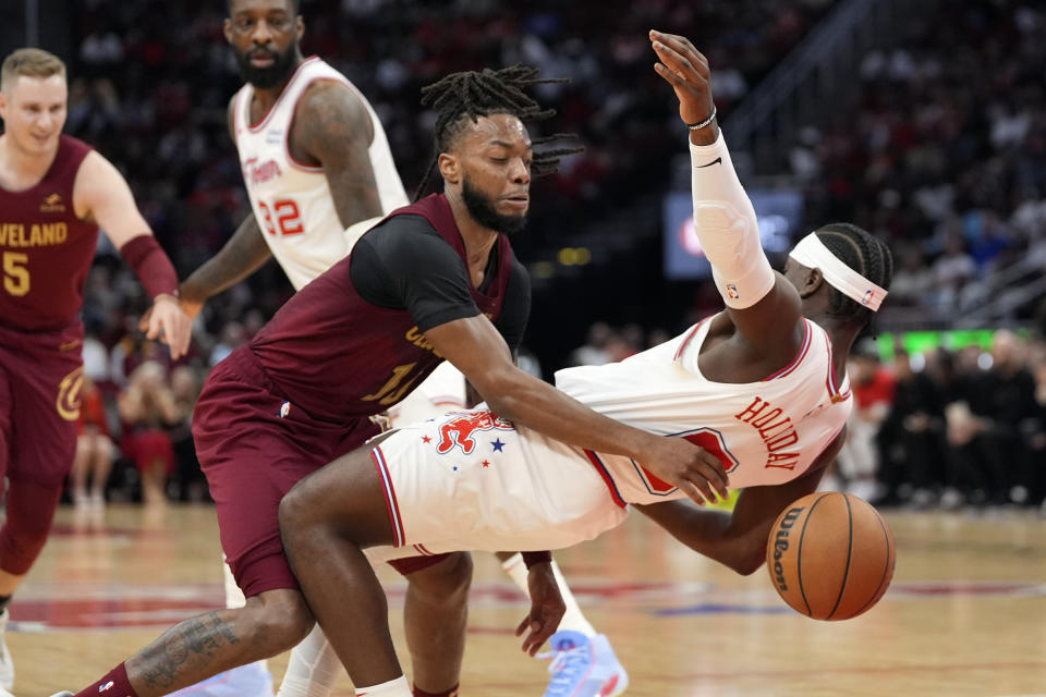 Cleveland Cavaliers' Darius Garland is fouled by Houston Rockets' Aaron Holiday (0) during the first half of an NBA basketball game Saturday, March 16, 2024, in Houston. (AP Photo/David J. Phillip)