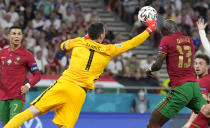 Portugal's Danilo Pereira, right, and France's goalkeeper Hugo Lloris collide as they compete for the ball during the Euro 2020 soccer championship group F match between Portugal and France at the Puskas Arena, Budapest, Hungary, Wednesday, June 23, 2021. (AP Photo/Darko Bandic,Pool)