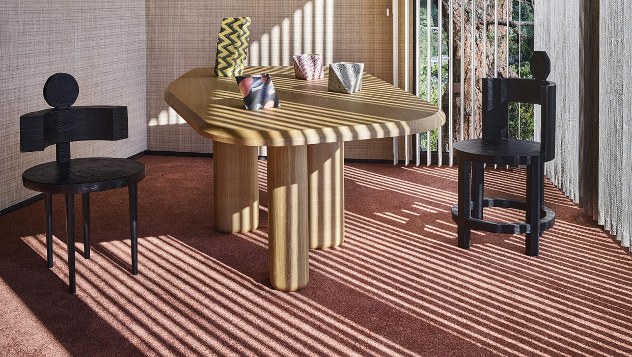  contemporary dining table and black chairs on a soft red carpet 