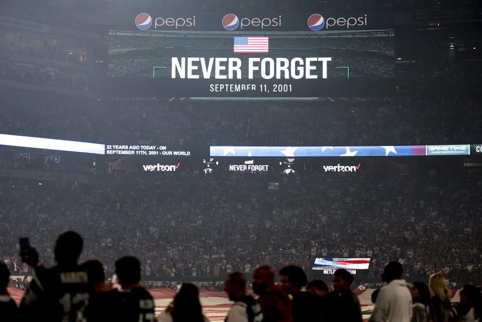 Fans watch as an American flag is stretched across the field during a 9/11 ceremony before the start of an NFL football game between the New York Jets and the Buffalo Bills, Monday, Sept. 11, 2023, in East Rutherford, N.J. (AP Photo/Adam Hunger)