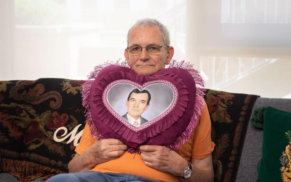 Martin Parr clutching a cushion displaying a picture of his younger self - Lee Thomas/Lee Thomas