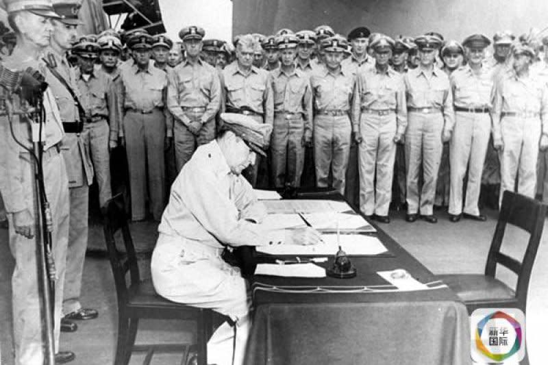 美國太平洋戰區最高統帥麥克阿瑟將軍在美國「密蘇里號」戰艦上簽署日本投降書。（新華社）