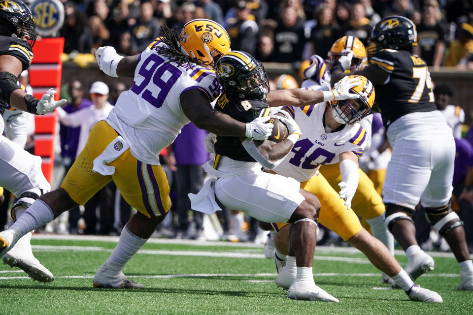 Oct 7, 2023; Columbia, Missouri, USA; Missouri Tigers running back Nathaniel Peat (8) runs the ball and is tackled by LSU Tigers defensive tackle Jordan Jefferson (99) and LSU Tigers linebacker Whit Weeks (40) during the second half at Faurot Field at Memorial Stadium. Mandatory Credit: Denny Medley-USA TODAY Sports