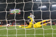 Roma's goalkeeper Mile Svilar, bottom, fails to save the ball as Leverkusen's Florian Wirtz, top, scores his side's opening goal during the Europa League semifinal first leg soccer match between Roma and Bayer Leverkusen at Rome's Olympic Stadium in Rome, Italy, Thursday, May 2, 2024. (AP Photo/Andrew Medichini)