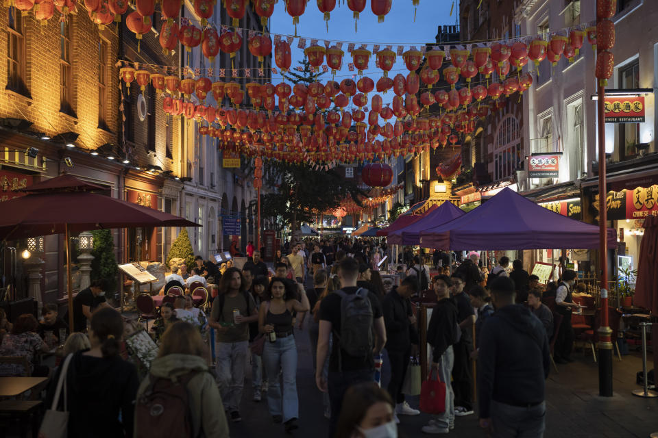 People walk in Gerrard Street the heart of Chinatown in London, Sunday, Sept. 11, 2022. (AP Photo/Felipe Dana)
