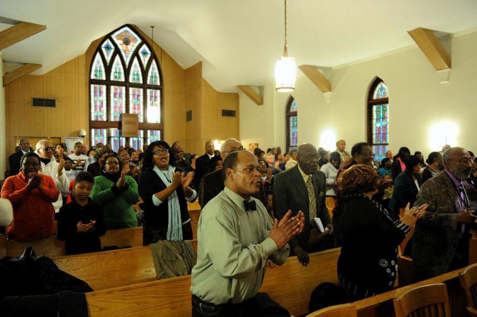 People stand and clap during the music portion of the Black History Committee's celebration of Dr. Martin Luther King, Jr's birthday at Greater Norris Chapel Baptist Church in Henderson, Ky Sunday Jan. 19, 2014. (AP Photo/The Gleaner, Darrin Phegley)