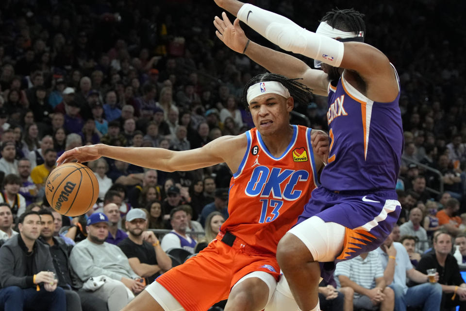 Oklahoma City Thunder forward Ousmane Dieng (13) drives on Phoenix Suns forward Josh Okogie during the second half of an NBA basketball game, Wednesday, March 8, 2023, in Phoenix. Phoenix won 132-101. (AP Photo/Rick Scuteri)