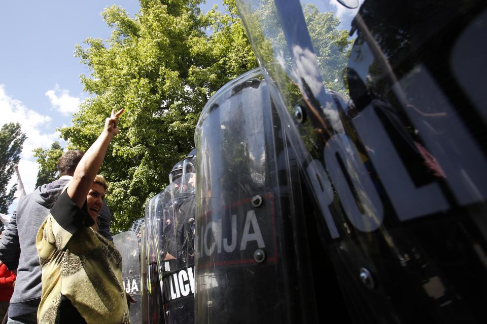 A Bosnian woman protests in front of a police cordon during a protest in the Bosnian capital of Sarajevo on Friday, May 9, 2014. A few hundred people from different parts of Bosnia have been protesting in Sarajevo over the high unemployment rate in the country and alleged government corruption. Protesters walked to the Sarajevo Library - a landmark destroyed during the Bosnian war - which is to be officially reopened today after reconstruction that has taken 18 years at the cost of over 16 million euros. They said they will continue the protest during the official ceremony to reopen the 19th century pseudo-Moorish construction that is expected to be attended by all top government officials as well as numerous international dignitaries. (AP Photo/Amel Emric)