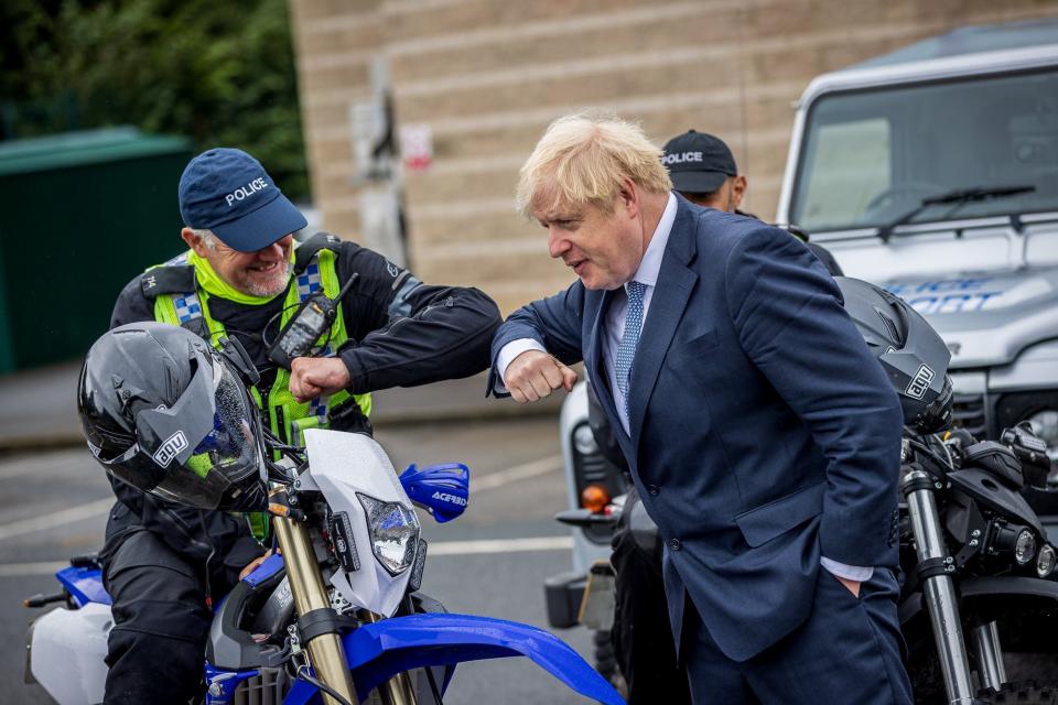 British Prime Minster Boris Johnson bumps elbows with a police officer during a visit to North Yorkshire Police t (REUTERS)