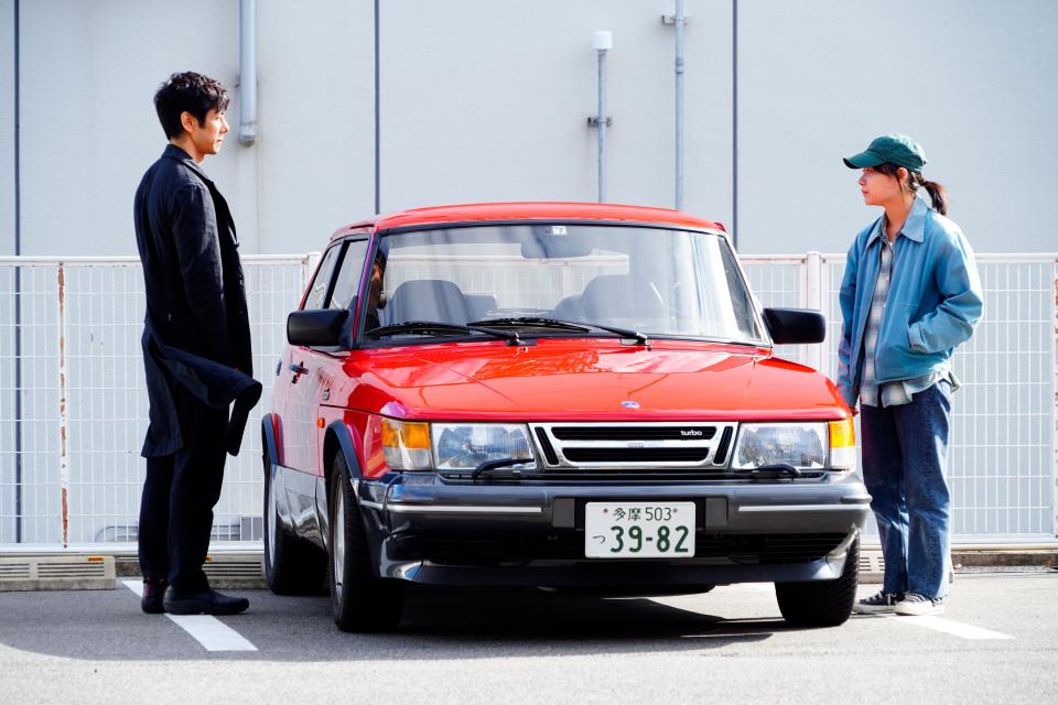 Kafuku (Hidetoshi Nishijima, left) reluctantly agrees to let Watari (Toko Miura) drive his car.