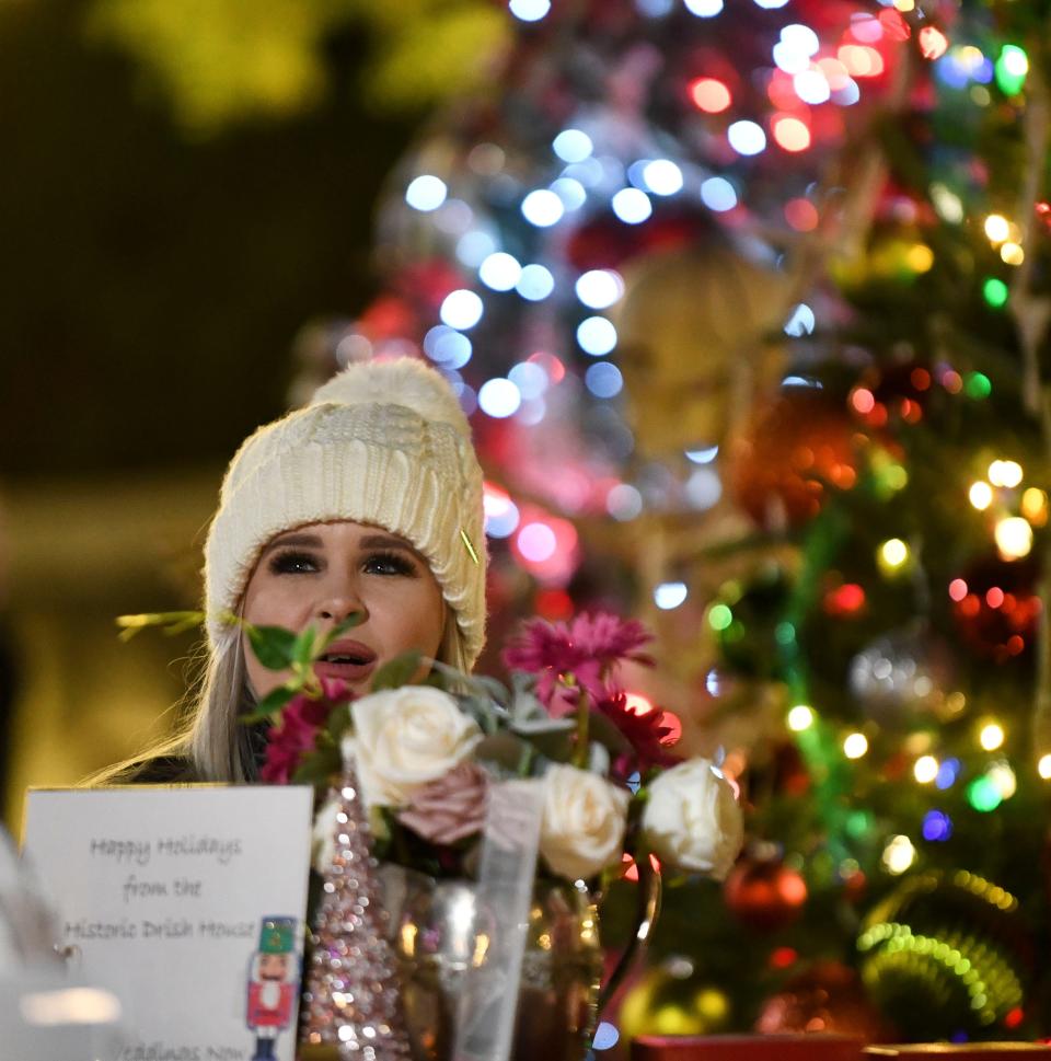 Crowds of viewers walked the paths on Nov. 21, 2022, to view the decorated trees in the Tinsel Trail. Deanna Dockery mans the table in front of the Drish House tree.