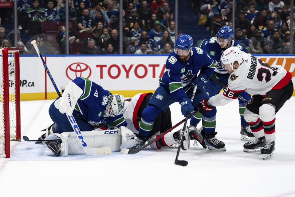 Vancouver Canucks goaltender Thatcher Demko (35) stops Ottawa Senators' Erik Brannstrom (26) as Vancouver's Filip Hronek (17) and Quinn Hughes (43) watch during the second period of an NHL hockey game Tuesday, Jan. 2, 2024, in Vancouver, British Columbia. (Ethan Cairns/The Canadian Press via AP)