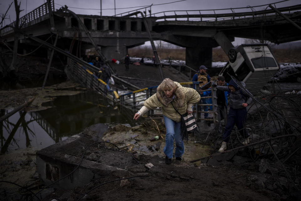 A woman runs as she flees with her family across a destroyed bridge in the outskirts of Kyiv, Ukraine, Wednesday, March 2. 2022. This was the year war returned to Europe, and few facets of life were left untouched. Russia’s invasion of its neighbor Ukraine unleashed misery on millions of Ukrainians, shattered Europe’s sense of security, ripped up the geopolitical map and rocked the global economy. The shockwaves made life more expensive in homes across Europe, worsened a global migrant crisis and complicated the world’s response to climate change. (AP Photo/Emilio Morenatti)