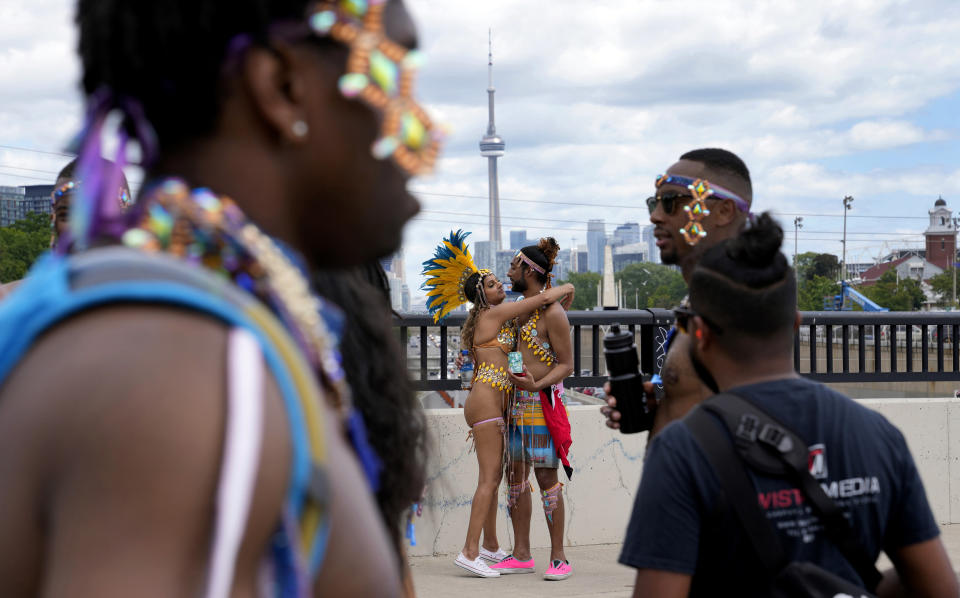 Masqueraders hug during the Caribbean Carnival parade in Toronto, Canada, Saturday, July 30, 2022. The 55th annual parade returned to the streets after the COVID-19 pandemic cancelled it for two years in a row. (AP Photo/Kamran Jebreili)