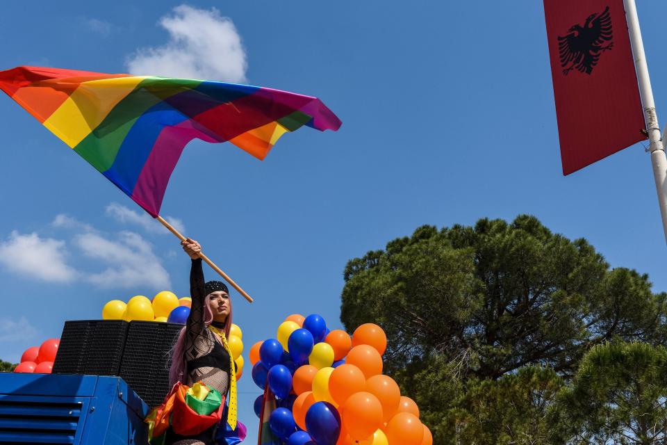 An Albanian LGBTQ activist waves a rainbow flag as she attends Tirana Gay Pride to mark the International Day Against Homophobia and Transphobia (IDAHOT) on the main boulevard in Tirana on May 13, 2018.